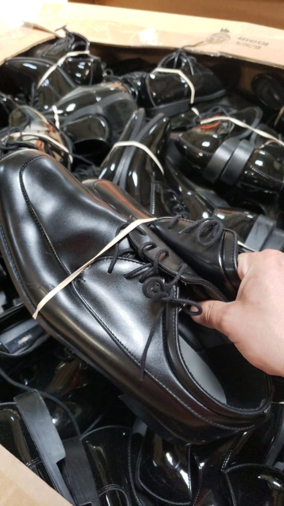 black leather shoes being picked up by person